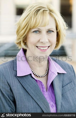 Blonde Business Woman in a Purple Shirt and Grey Suit