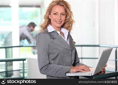 blonde businesswoman all smiles with laptop