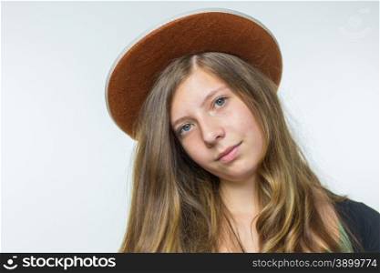 Blonde caucasian teenage girl with long blonde hair wearing brown hat isolated on white background