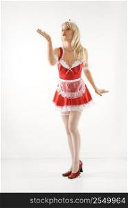 Blonde Caucasian young woman in french maid oufit blowing kiss.