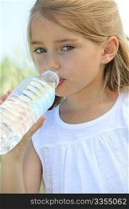 Blonde cute little girl drinking water
