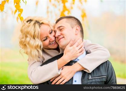 blonde embraces her lover outdoors in autumn park