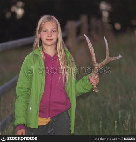 Blonde girl holding antler