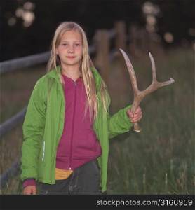 Blonde girl holding antler