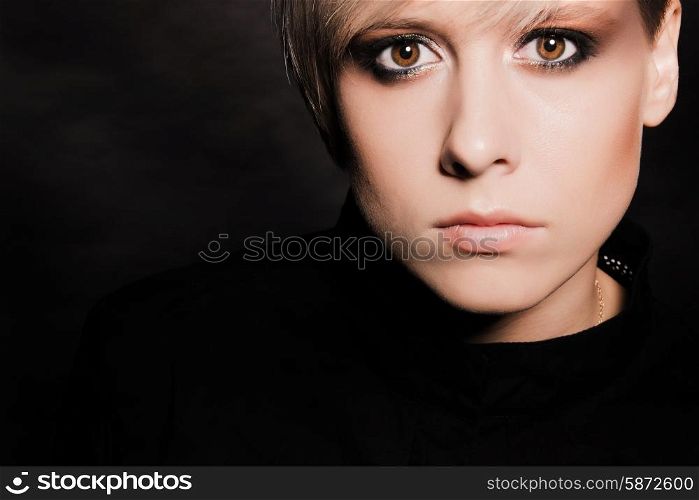 Blonde girl with a short stylish haircut on a dark background