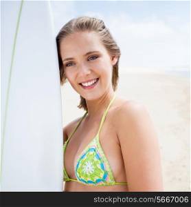 Blonde girl with a surf board on the beach