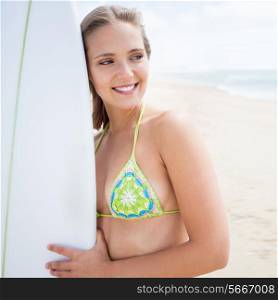Blonde girl with a surf board on the beach