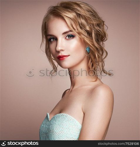 Blonde girl with elegant curly and shiny hairstyle. Beautiful model woman with curly hairstyle. Care and beauty hair products. Perfect make-up