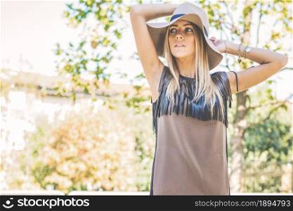 Blonde girl with hat in a public park
