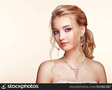 Blonde Girl with Long and shiny Curly Hair. Beautiful Model Woman with Curly Hairstyle. Care and Beauty Hair products. Perfect Make-Up and Jewelry