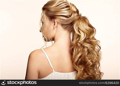 Blonde Girl with Long and shiny Curly Hair. Beautiful Model Woman with Curly Hairstyle. Care and Beauty Hair products. Care and Beauty of Hair