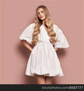 Blonde girl with perfect makeup. Smiling beautiful model woman with long curly hairstyle. Care and beauty hair products. Model in white festive dress