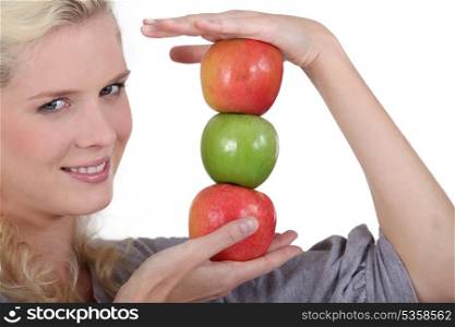 Blonde holding pile of apples
