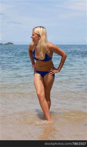 blonde in a bathing suit having fun on the beach. Sea, islands.