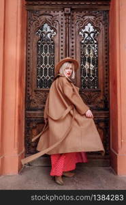 blonde in red dress and hat in the city. Fashion style portrait of blonde model. girl posing at the camera.. blonde in red dress and hat in the city. Fashion style portrait of blonde model. girl posing at the camera