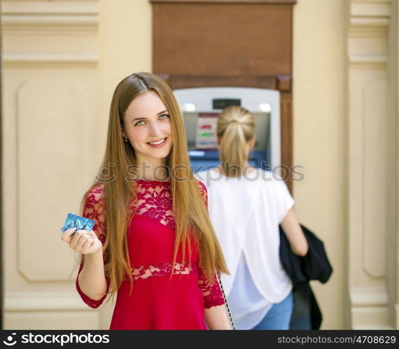 Blonde lady using an automated teller machine . Woman withdrawing money or checking account balance