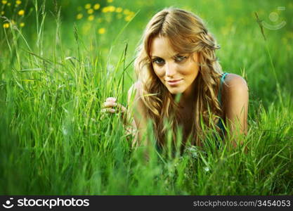 blonde lays on green grass