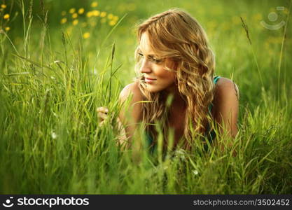 blonde lays on green grass