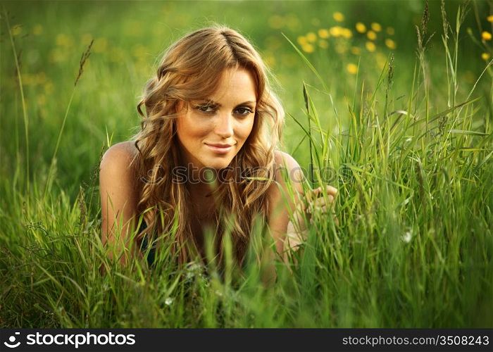 blonde lays on green grass