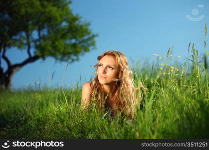 blonde lays under the tree