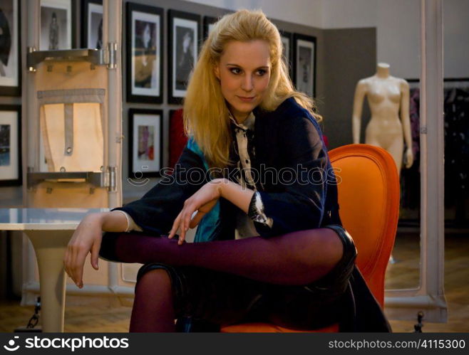 Blonde leans elbow on Tulip table in appartment gallery