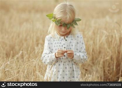 blonde little girl in the field with spikelets