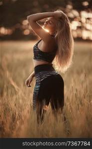 blonde long hair nature summer / happy adult girl with developing in the wind long blonde hair in the summer field