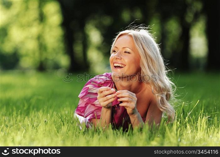 blonde lying on green grass