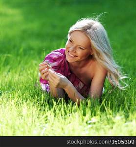 blonde lying on green grass