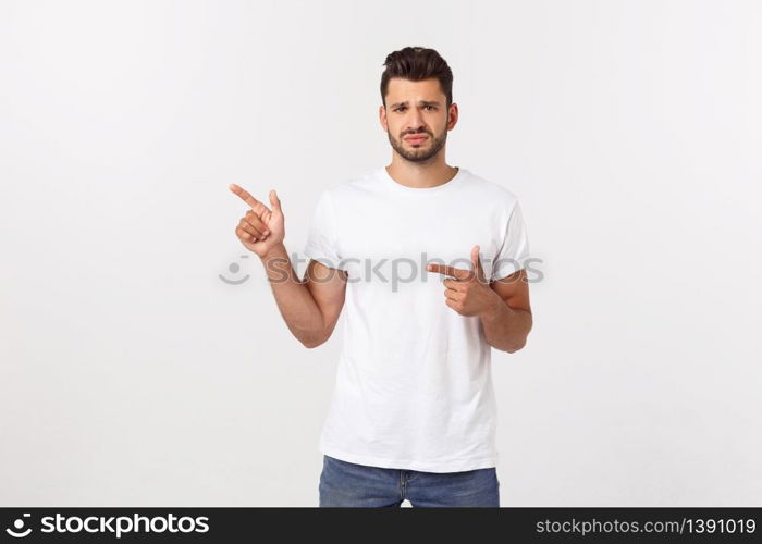 Blonde man over isolated yellow wall frightened and pointing to the side. Blonde man over isolated yellow wall frightened and pointing to the side.