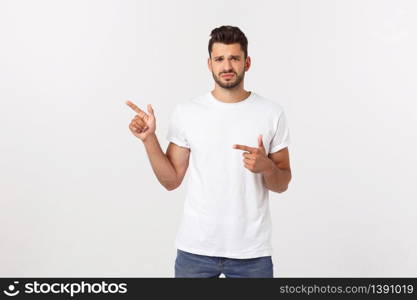 Blonde man over isolated yellow wall frightened and pointing to the side. Blonde man over isolated yellow wall frightened and pointing to the side.