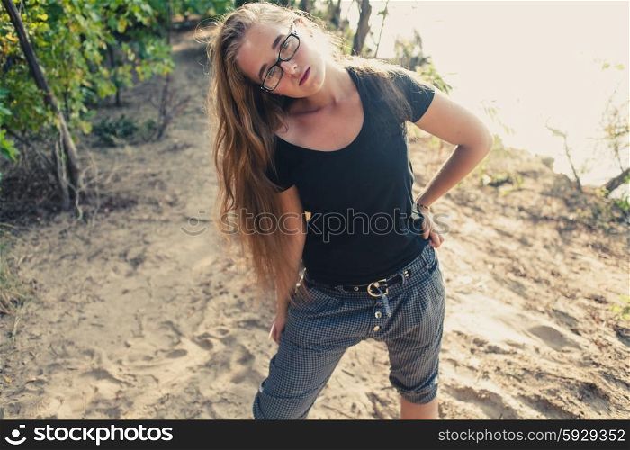Blonde posing outdoors on sand.