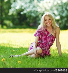 blonde sitting on green grass
