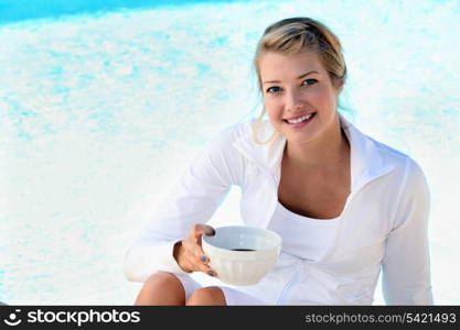 blonde sitting on the edge of swimming-pool