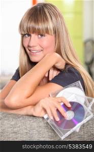 blonde teenager behind a couch and holding cd cases