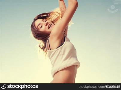Blonde teenager girl jumping happy with the blue sky in the background
