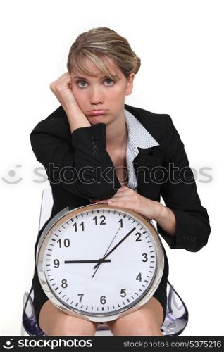 blonde with clock looking bored