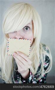 Blonde woman covering her face with a paper envelope