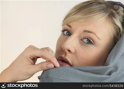 Blonde woman draped in a gray scarf