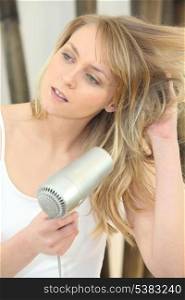 Blonde woman drying her hair