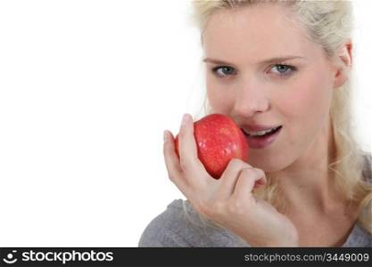 Blonde woman eating an apple