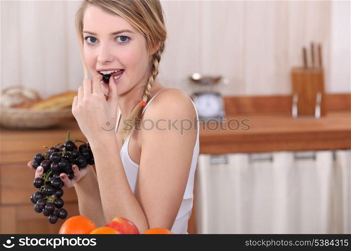 Blonde woman eating grapes