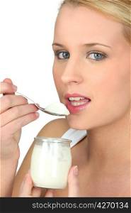 Blonde woman eating yogurt