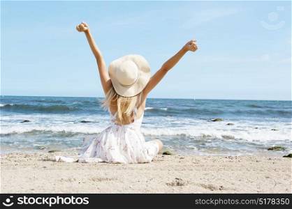 Blonde woman enjoy the sunny beach arm streatched. Travel concept