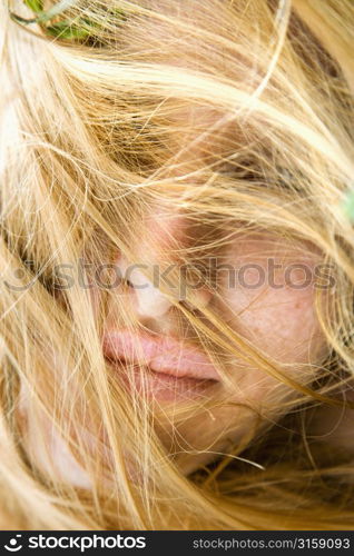 Blonde woman hiding behind hair