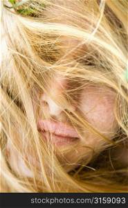 Blonde woman hiding behind hair