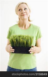 Blonde woman holding a plant