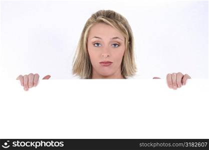 Blonde Woman Holding Sign with Sad Expression.