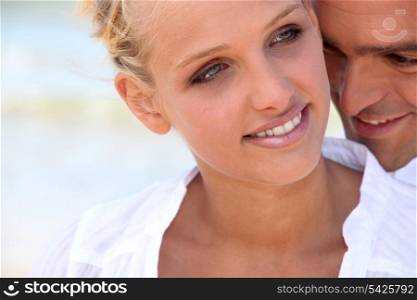 blonde woman hugged tenderly from the back by her partner