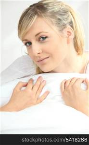 Blonde woman hugging pillow
